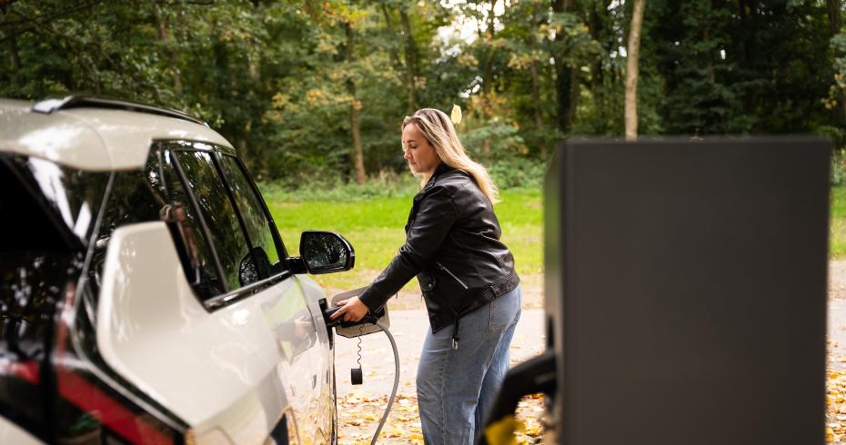 Vrouw laadt elektrische auto