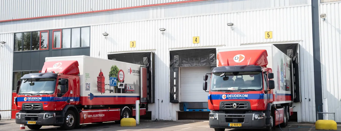 2 vrachtwagens staan te laden op een bedrijventerrein