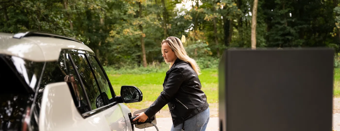 Vrouw laadt elektrische auto