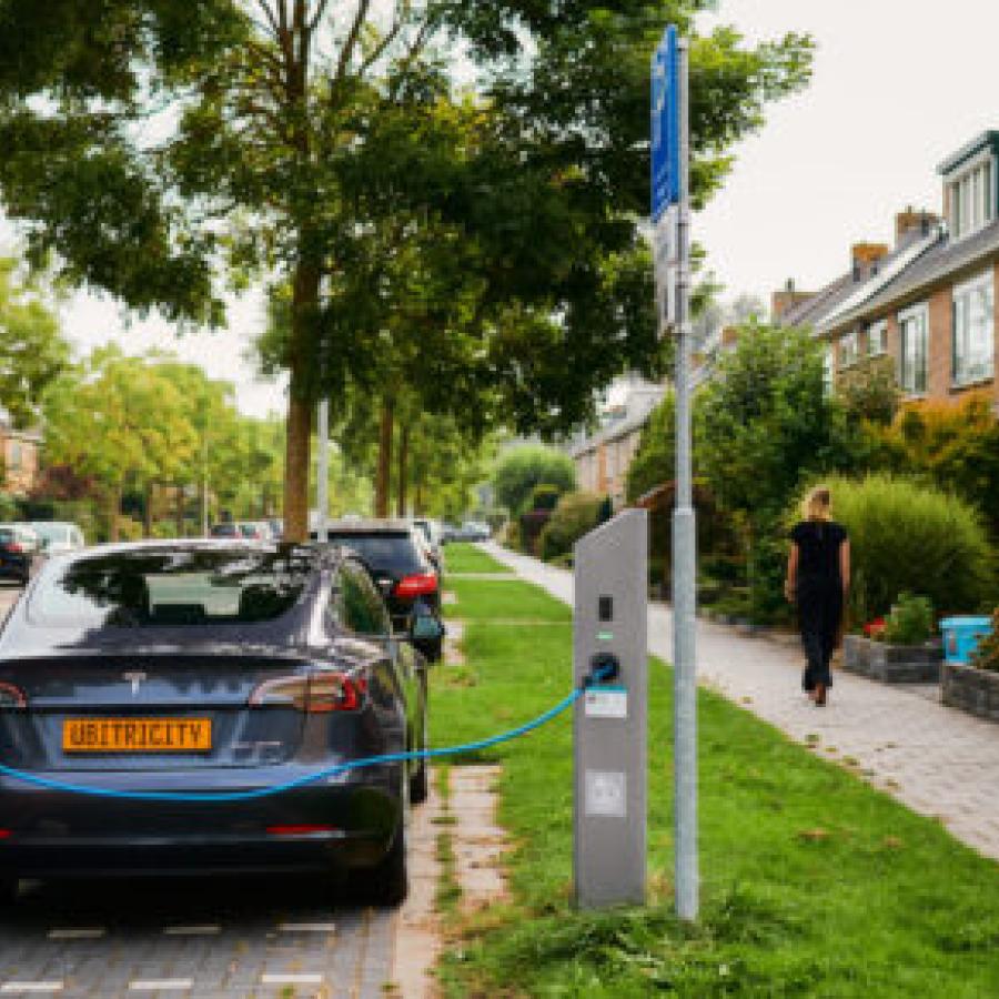vrouw staat te laden aan een ubitricity laadpaal