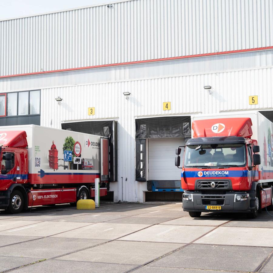 2 vrachtwagens staan te laden op een bedrijventerrein